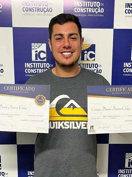 Aluno formado segurando os certificados do curso e da NR